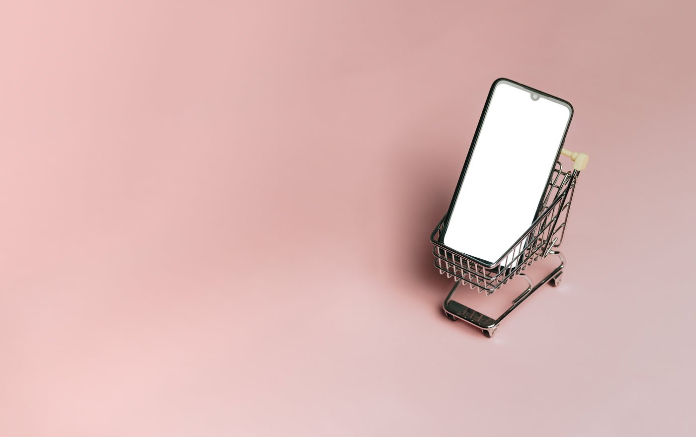 Miniature shopping cart with a mobile phone inside, an online shopping concept