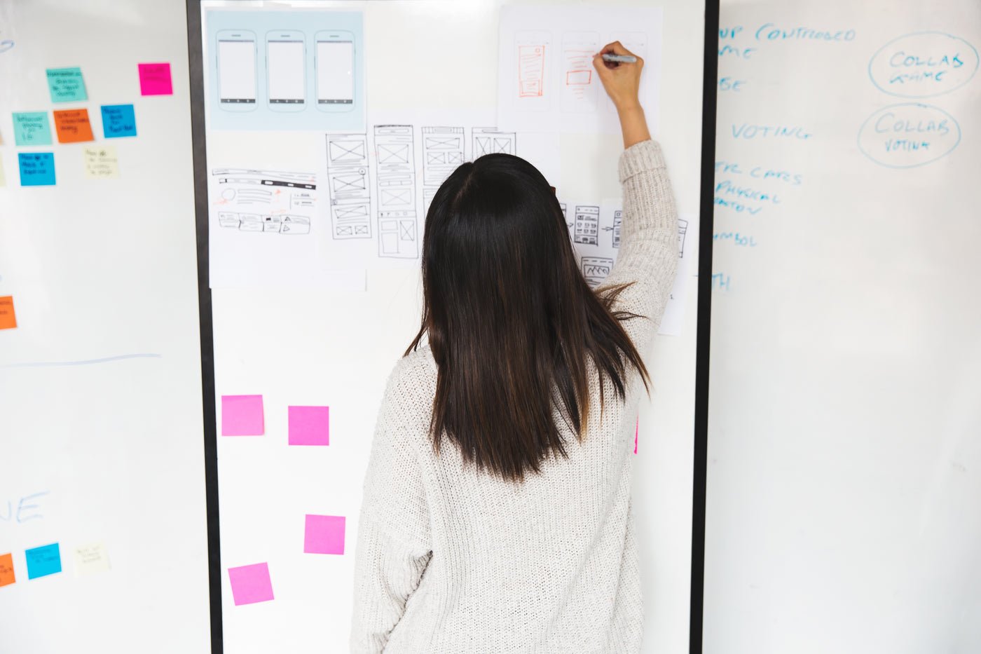 Designer drawing website mockups on a whiteboard, website development services from first sketch to launch