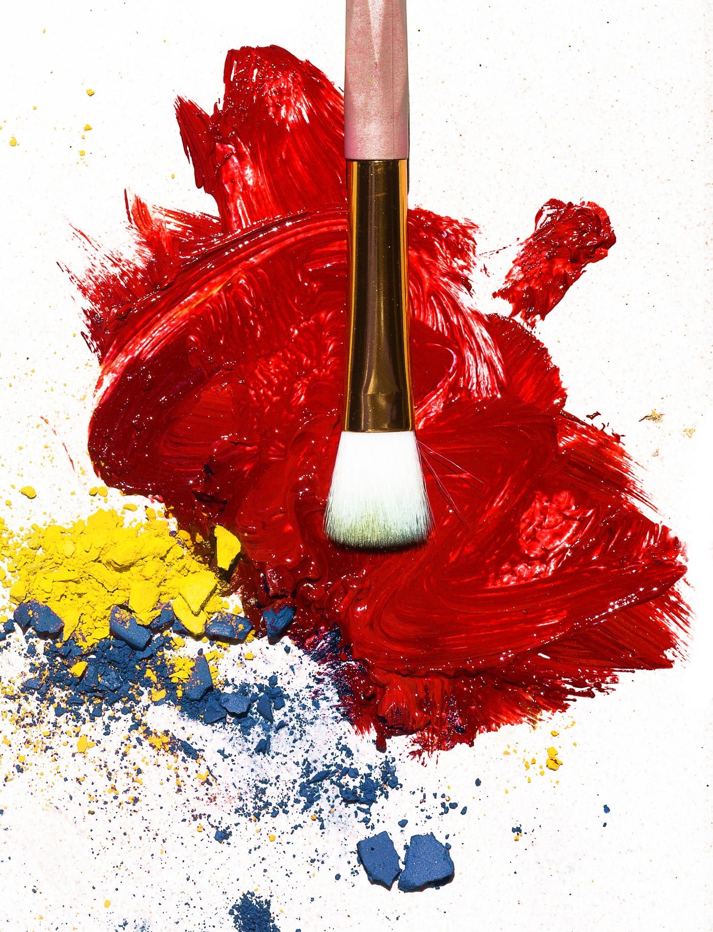 Makeup brush resting on red lipstick colour, beauty products