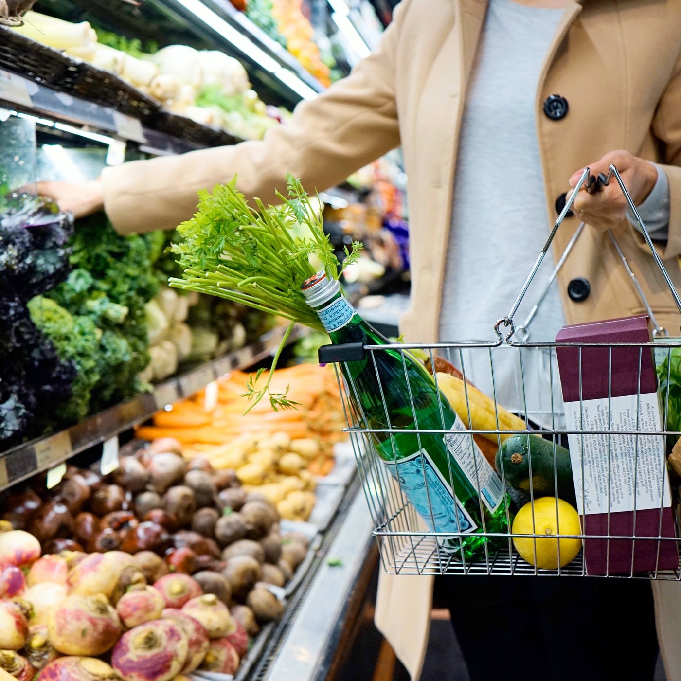 Shopper using a silver shopping basket to shop for groceries