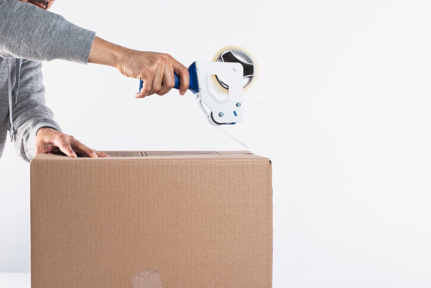 Sealing a parcel with a tape dispenser