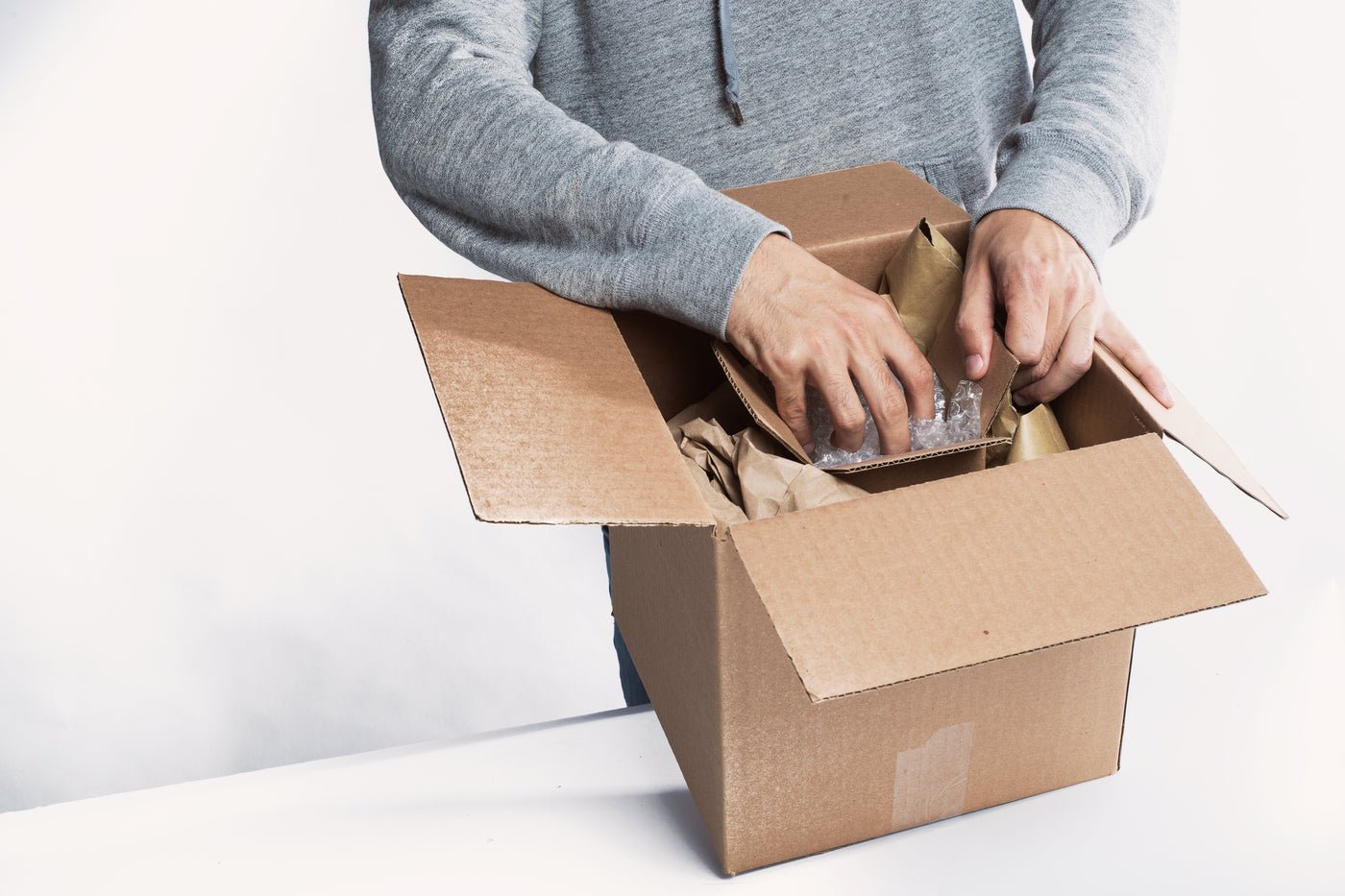Young man preparing a package for fulfilment, eBay account management for UK sellers